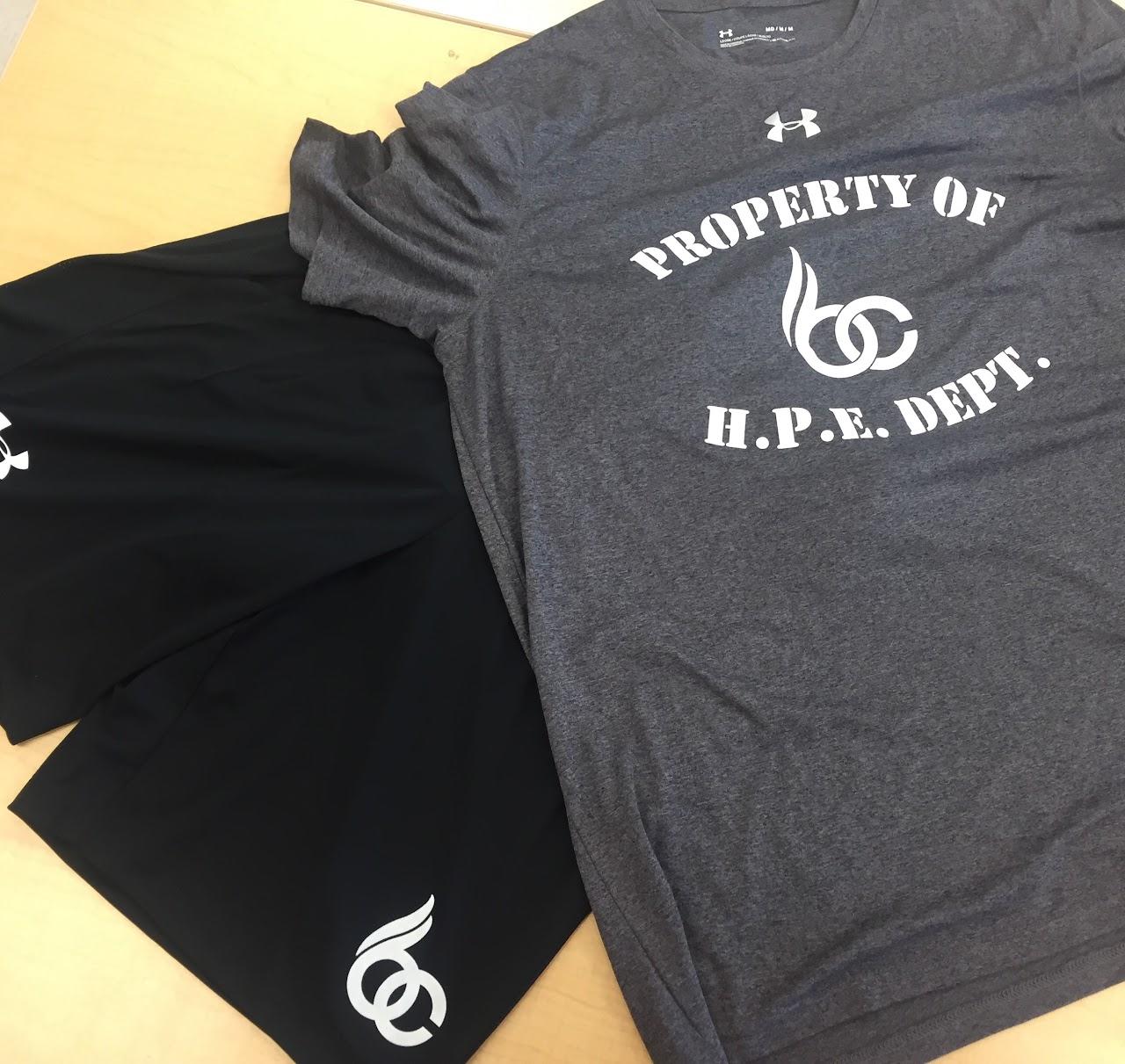 grey Tshirt reads Property of HPE department - lays on top of a pair of black shorts with BCSS logo