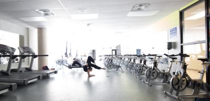 Student does acrobatic movement with gym equipment on either side