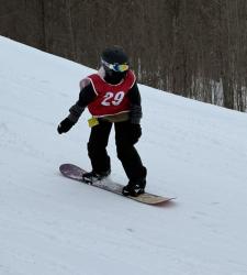 student wearing number 29 snowboarding down a hill