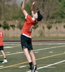 student jumping to catch frisbee