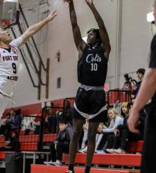 student shooting a basketball