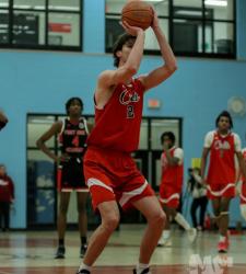 student shooting a basketball
