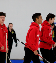 student curling team with brooms