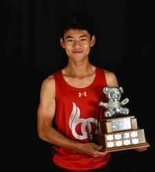 student standing with trophy