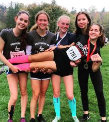 four students holding fifth student