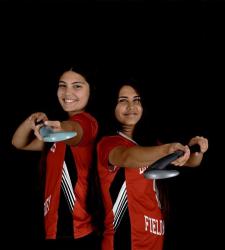 students holding field hockey sticks