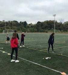 students hitting golf balls on field